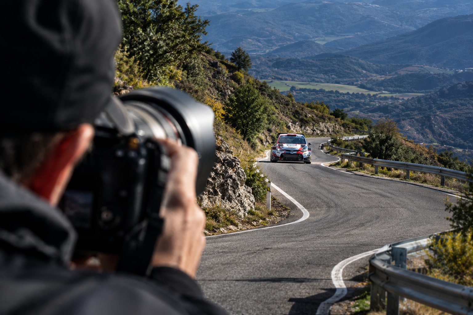 fotógrafo enfoca rally en carretera montañosa